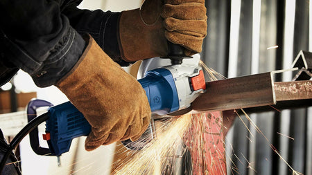 BOSCH DBX641S 6 In. X-LOCK Segmented Rim Diamond Blade cutting metal with sparks flying from grinder.