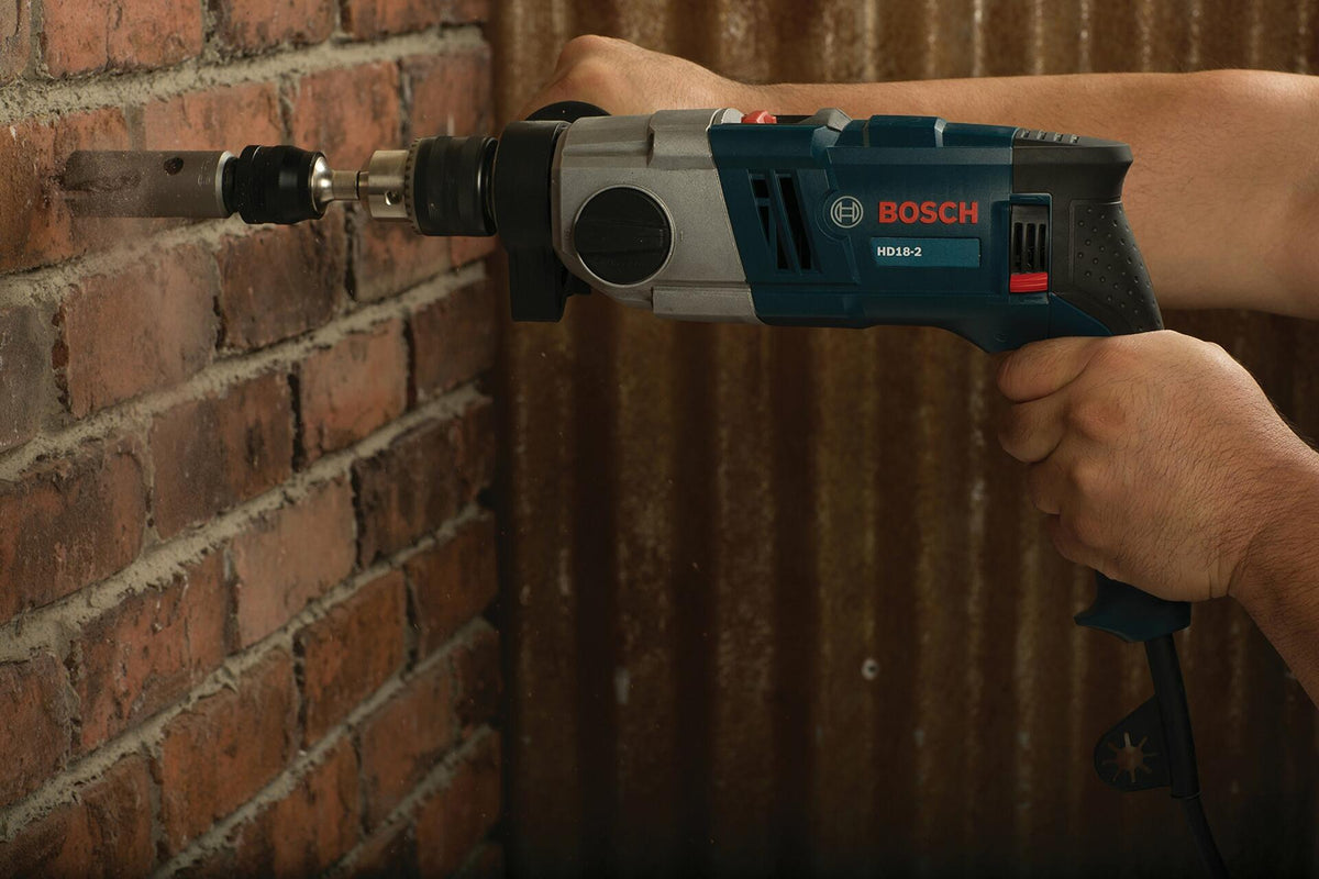 Bosch HD182RT 8.5 Amp 1/2 in. Two-Speed Hammer Drill in use drilling into brick wall with ergonomic grip design