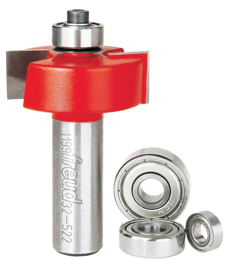 A professional studio photograph of the Freud 32-522 multi-rabbet router bit, showcasing its red Perma-SHIELD coating on the cutting head, silver TiCo carbide edges, and a polished 1/2-inch steel shank, shown alongside its included interchangeable ball bearings of various diameters.