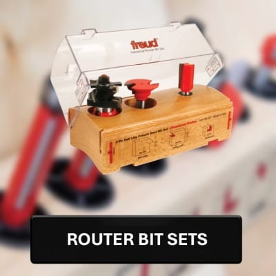 Router bit set with 'freud' branding on a blurred background of woodworking tools.