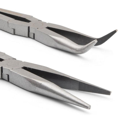 The pliers are positioned one above the other, with the jaws pointing towards the right side of the image. The jaws are silver-colored metal and are in sharp focus, highlighting the different tip designs. The top pair has curved, angled tips, while the bottom pair has pointed, needle-nose tips. The rest of the pliers are slightly out of focus, emphasizing the detail of the jaws.